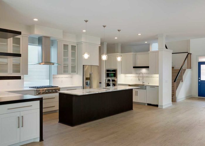 Kitchen with white cabinets and dark center island