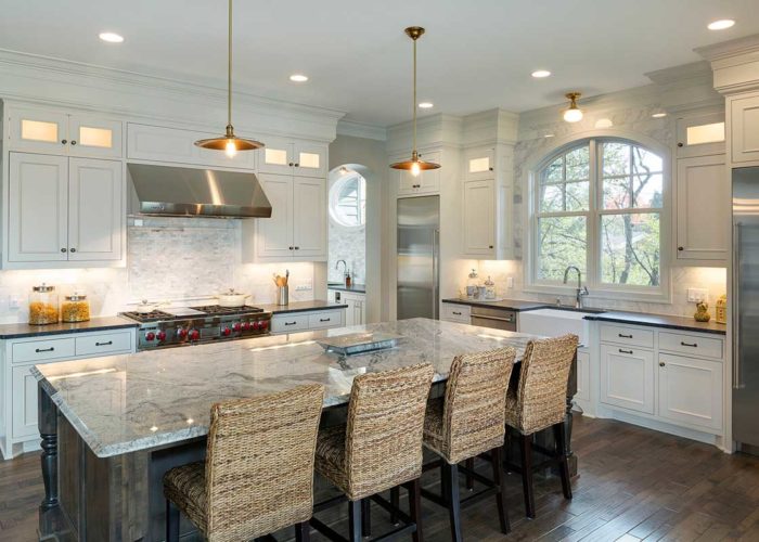 Large modern kitchen with white cabinets and stainless steel appliances
