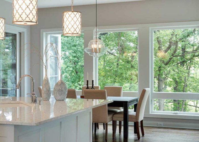 Modern kitchen lighting and large windows with view of yard