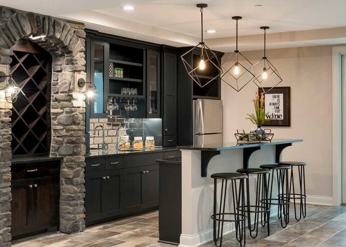 Basement bar with decorative lighting and black cabinets
