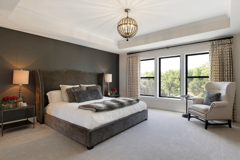 Master bedroom with large windows and dark brown accent wall