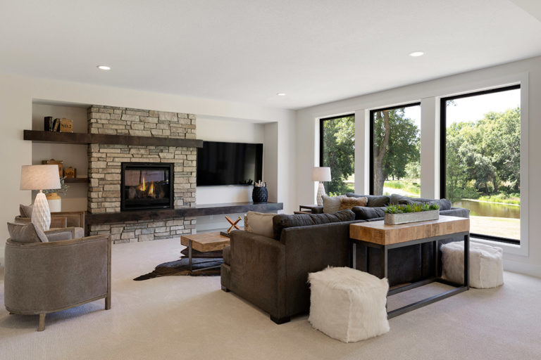 Basement with large windows and brown furniture