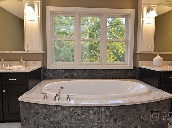Luxury bathroom with black cabinets and tub