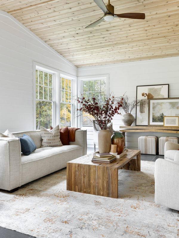 Open living room with large windows. White and wood decor