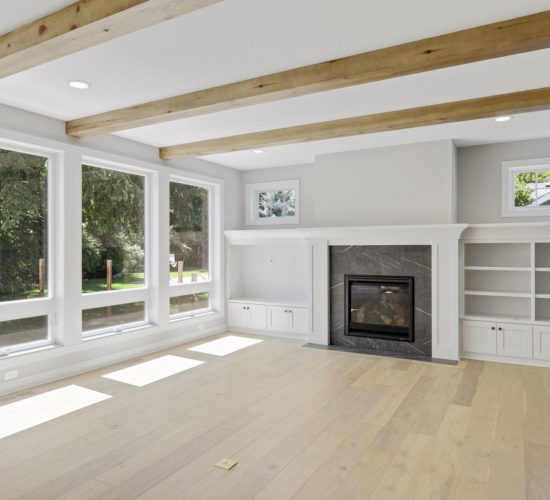 great room with beamed ceiling, built-ins, and fireplace