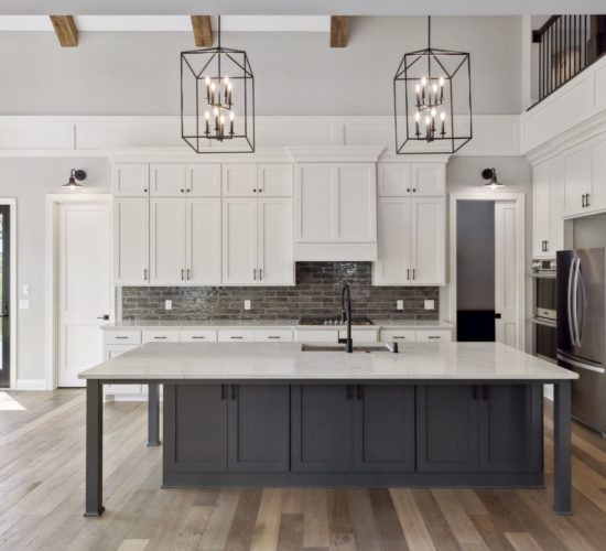 Two story kitchen with blue island and large hanging pendents