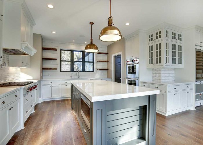 White kitchen with teal accent island and floating shelves