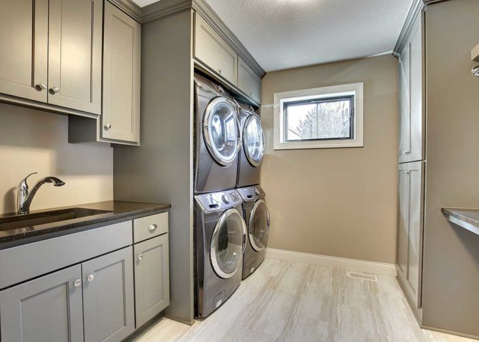 Grey laundry room with two washer and dryer units